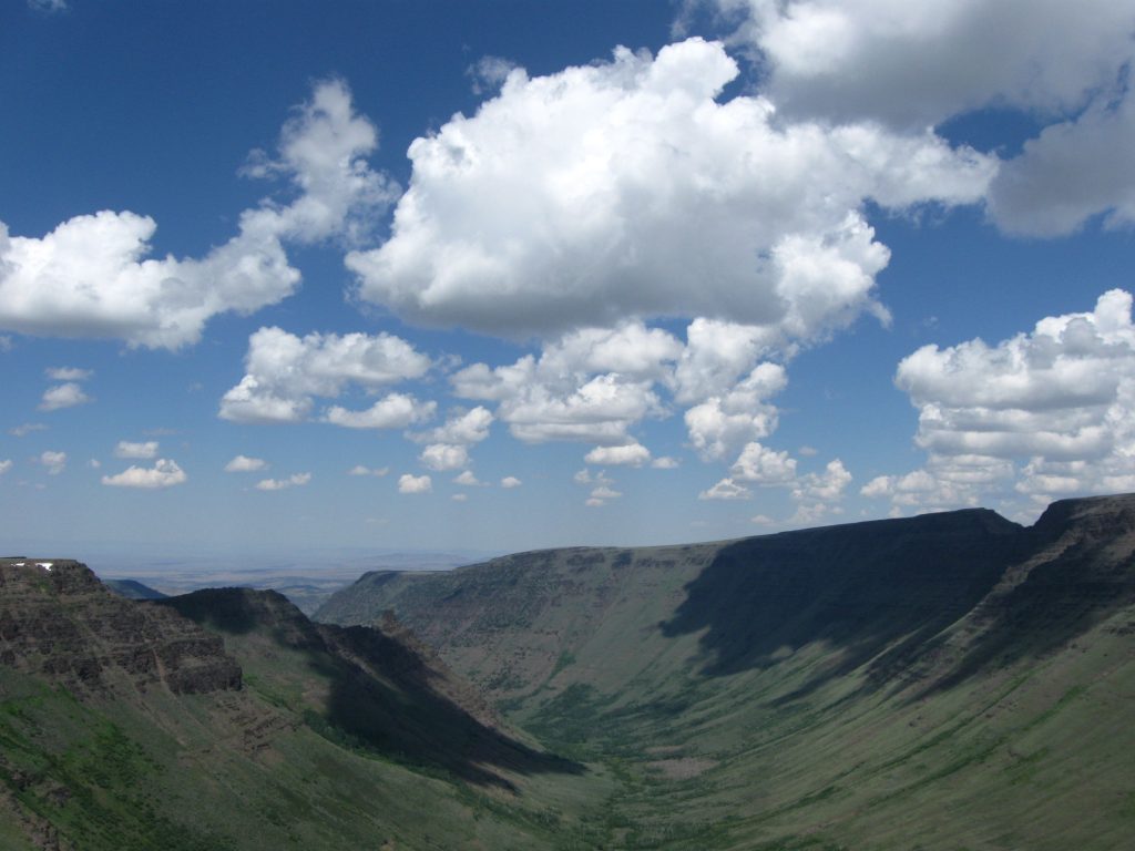 Cumulus clouds moving over a springtime canyon in the Oregon desert.