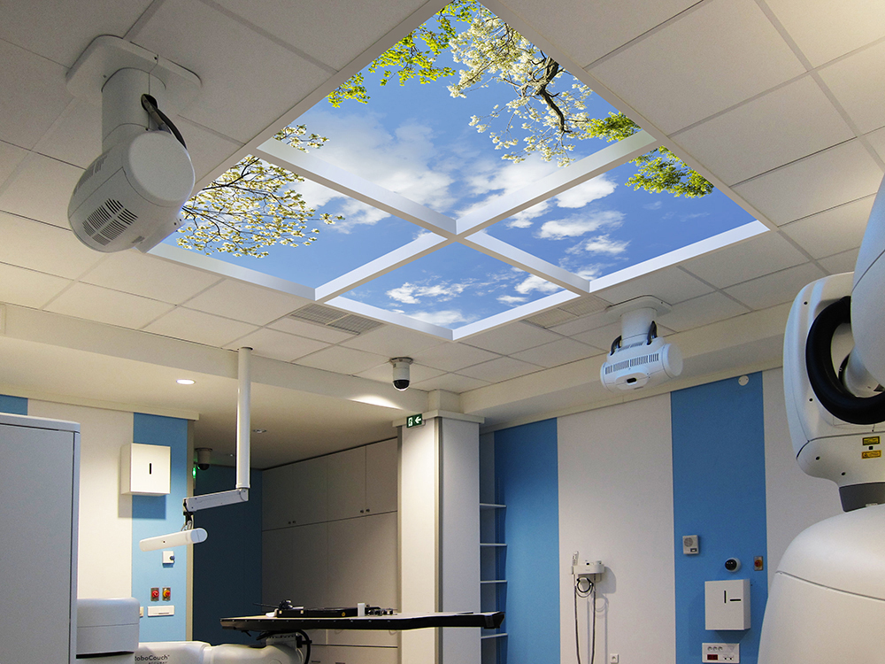 An overhead illusion to open skies (fake skylight) relaxes patients before the treatment.